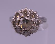 An 18 ct white gold diamond cluster ring. Ring size N. 4.5 grammes total weight.