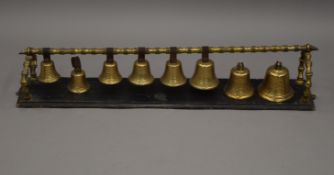 A set of eight 19th century brass hanging bells. 86 cm long.