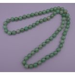 A string of jade beads. 85 cm long.