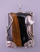 A silver mounted tigers eye pendant. 5 cm x 4 cm excluding suspension loop.