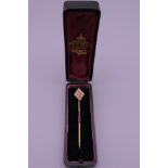 Am 18 ct gold seed pearl stick pin, boxed. 6.5 cm long. 2.5 grammes total weight.