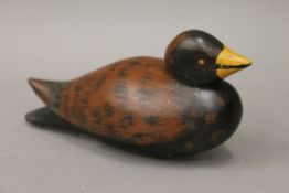 A painted wooden decoy duck. 24 cm long.