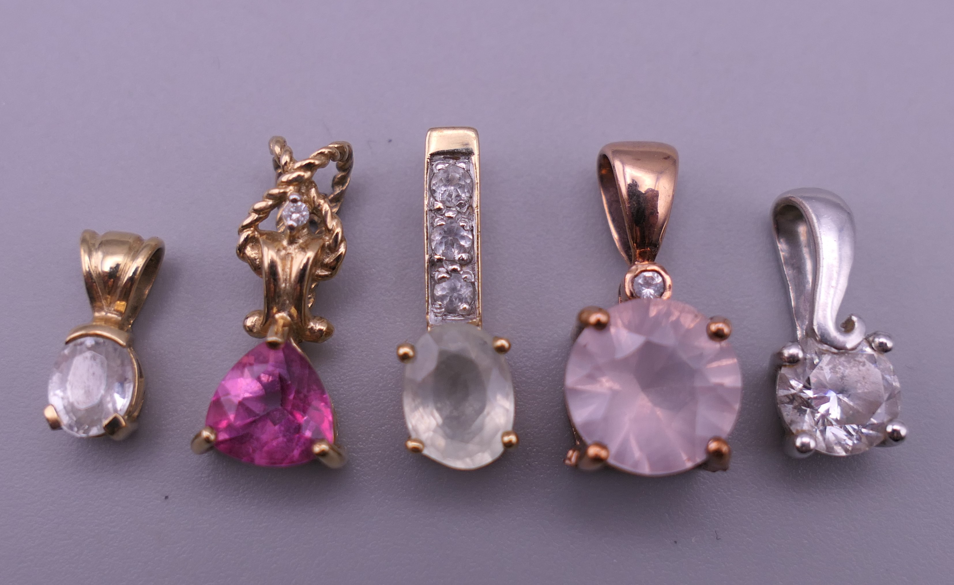 Five 9 ct gold pendants. Largest 1.5 cm high. 4.9 grammes total weight.