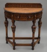 An early 20th century carved oak demi lune side table. 76 cm wide.