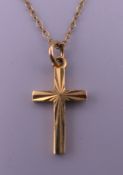 A 9 ct gold cross pendant on a 9 ct gold chain. Cross 1.75 cm high, chain 40 cm long. 1.9 grammes.