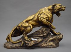 A Belgian bronzed terracotta model of a lion, modelled standing on a rocky outcrop,