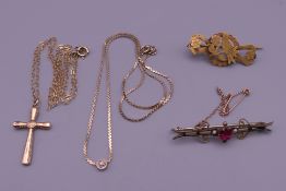 A quantity of gold jewellery to include two brooches, a cross on a chain and another chain.