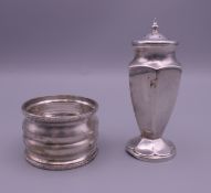 A Continental white metal pepper shaker and a silver napkin ring.