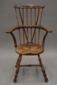 A 19th century oak stick back arm chair. 64 cm wide.