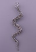 A silver snake form pendant. 8.5 cm long.