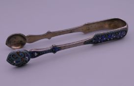 A pair of silver sugar tongs bearing Russian marks. 14 cm long.