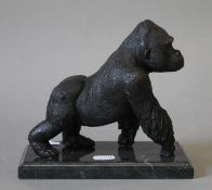 A bronze model of a gorilla on a plinth base. 16 cm high.