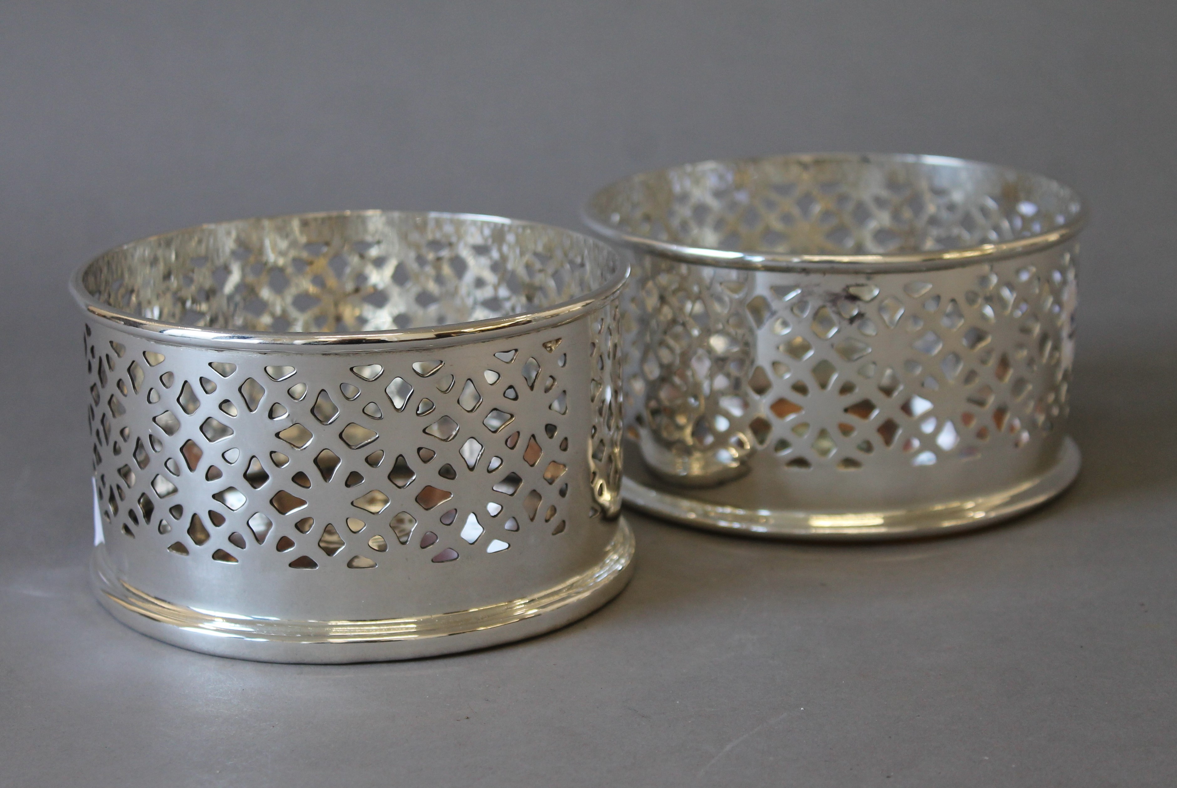 A pair of silver plated coasters. 12.5 cm diameters.
