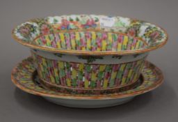 A 19th century Chinese Canton porcelain basket on stand. The basket 24.5 cm wide.