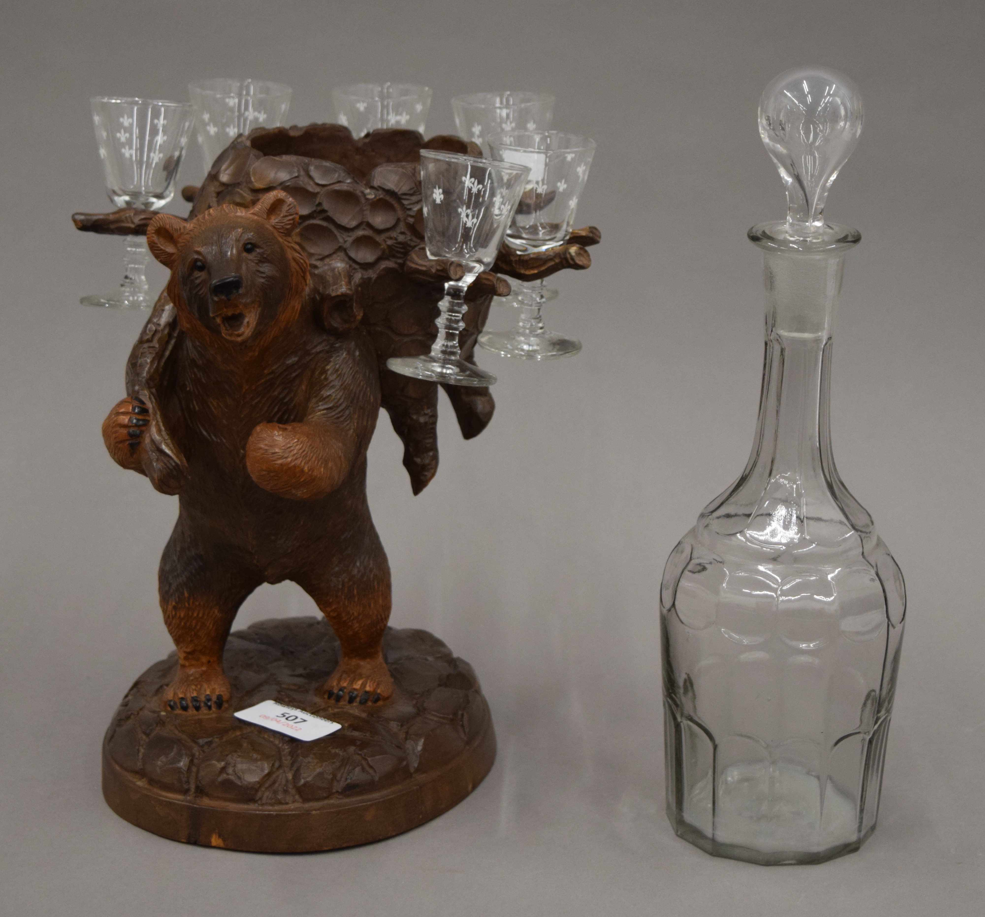 A Blackforest carved wooden liqueur set stand formed as a bear,
