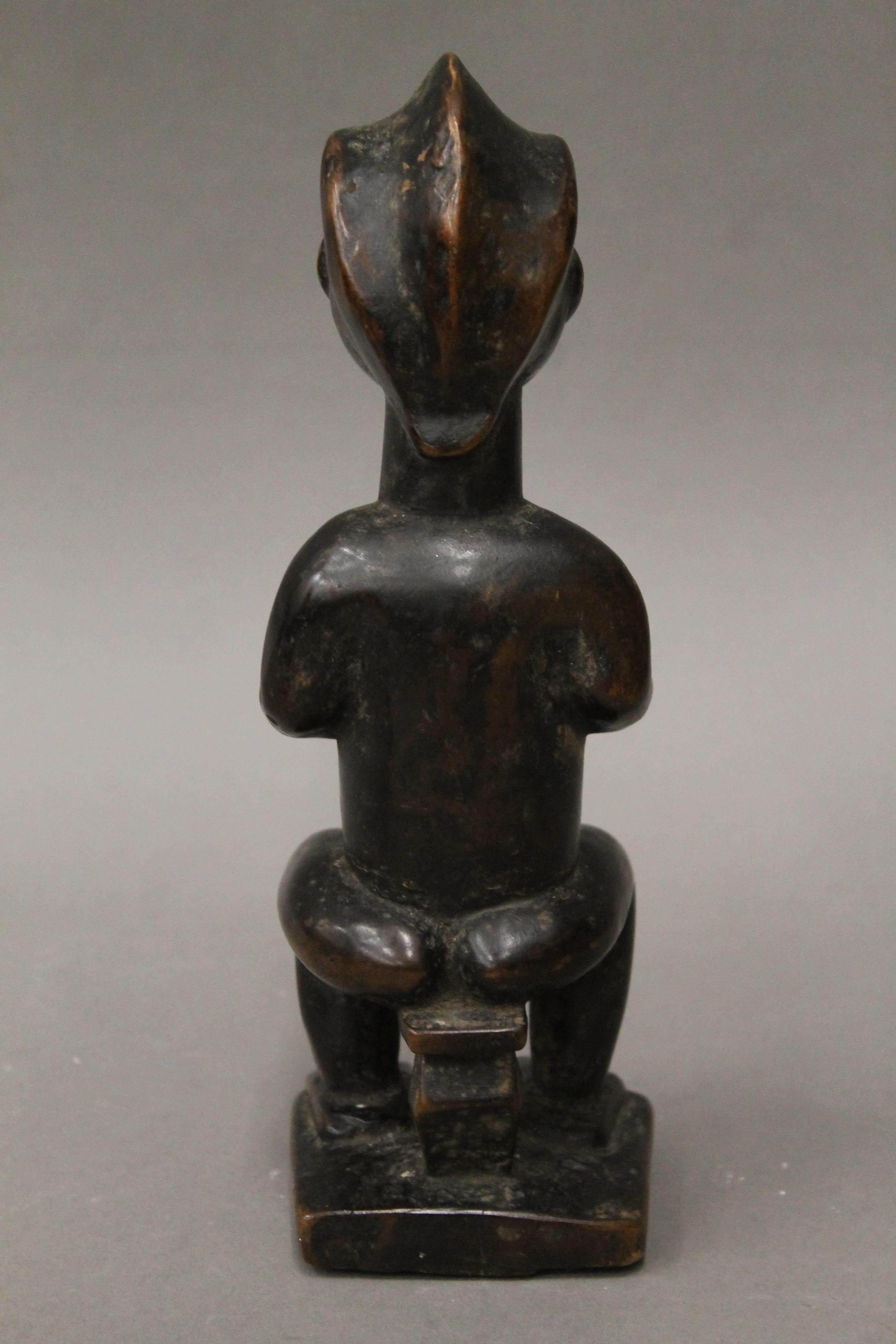 A tribal wooden figure with studded and scarified face. 23 cm high. - Image 4 of 4