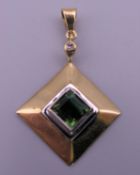 An 18 ct gold, diamond and green tourmaline set pendant. 2.5 x 2.5 cm excluding suspension loop. 4.