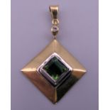 An 18 ct gold, diamond and green tourmaline set pendant. 2.5 x 2.5 cm excluding suspension loop. 4.