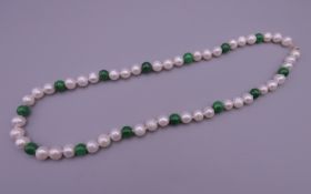 A jade and pearl necklace with a 14 ct gold clasp. 43 cm long.
