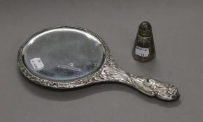 A silver cherub hand mirror and a silver pepper pot.