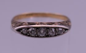 An 18 ct gold five stone diamond ring. Ring size N/O. 2.7 grammes total weight.