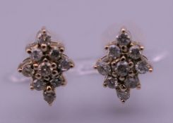 A pair of 9 ct gold and diamond earrings. 1 cm high.