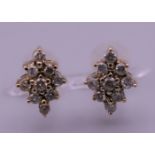 A pair of 9 ct gold and diamond earrings. 1 cm high.