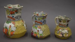 A graduated set of three Masons Ironstone jugs. The largest 17 cm high.