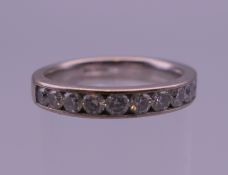 An 18 K white gold diamond set half hoop eternity ring. Ring size N.