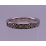 An 18 K white gold diamond set half hoop eternity ring. Ring size N.