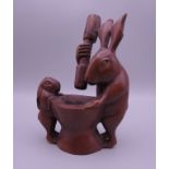 A Japanese wooden model of rabbits grinding a pestle and mortar. 10.5 cm high.