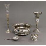 A silver bud vase, another, a plated coaster and a plated tea strainer.