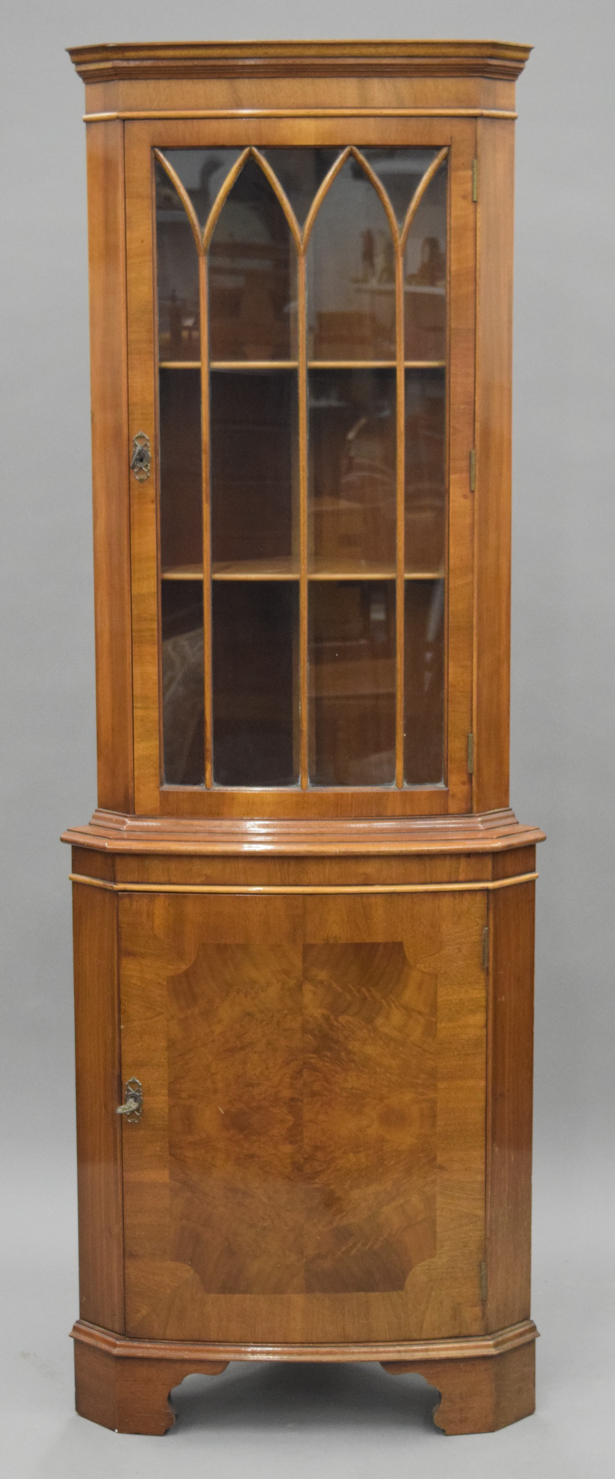 A modern walnut corner cabinet. 181 cm high.