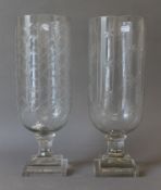 Two similar cut glass storm lamps. The largest 40.5 cm high.