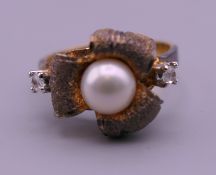 A 9 ct gold pearl set flowerhead ring. Ring size L. 3.5 grammes total weight.