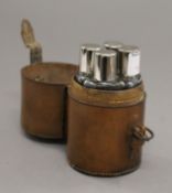 A leather cased set of four hunt flasks with plated lids. 13 cm high overall.
