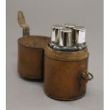 A leather cased set of four hunt flasks with plated lids. 13 cm high overall.