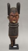 An African painted carved wooden tribal post, mounted on a display stand. 54 cm high overall.