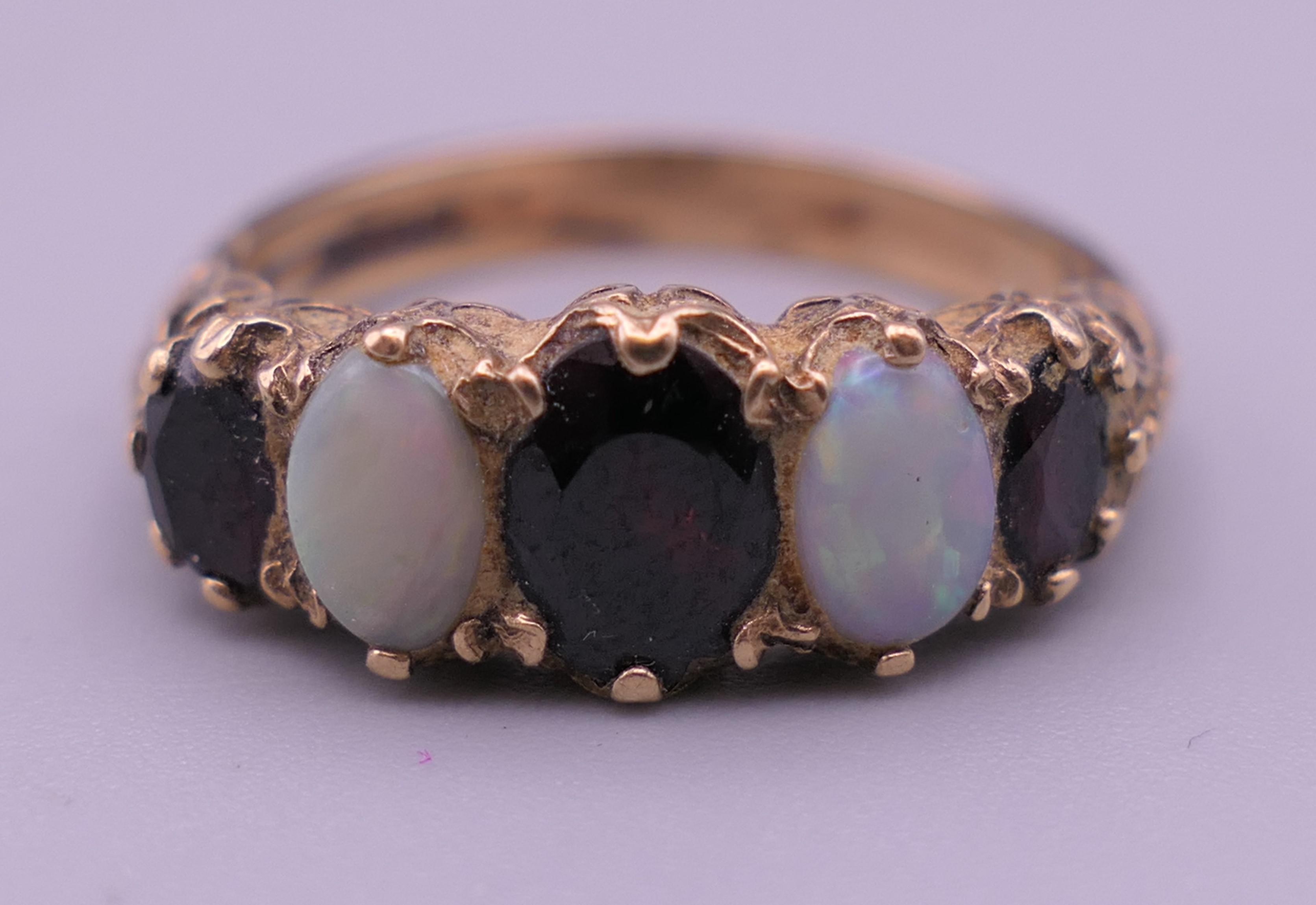 An unmarked gold, probably 9 ct gold, opal and garnet ring.