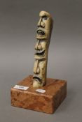 A carved bone totem type sculpture mounted on a marble base. 24 cm high.