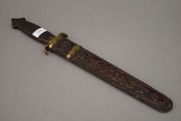 A vintage brass mounted Chinese short sword, the scabbard carved with a dragon and a phoenix.