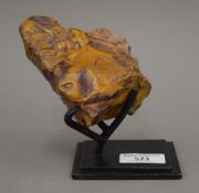 A yellow and red specimen stone on stand.