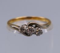 An 18 ct gold diamond trilogy ring. Ring size I/J. 2 grammes total weight.