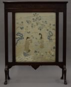 A Chinese silk panel mounted in a mahogany fire guard. 56 cm wide overall.