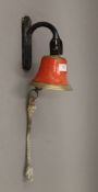 A wall mounted bell. 24 cm high.