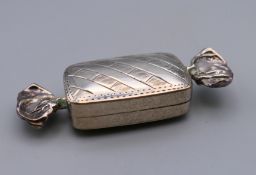 A silver box shaped as a wrapped sweet. 6 cm long.