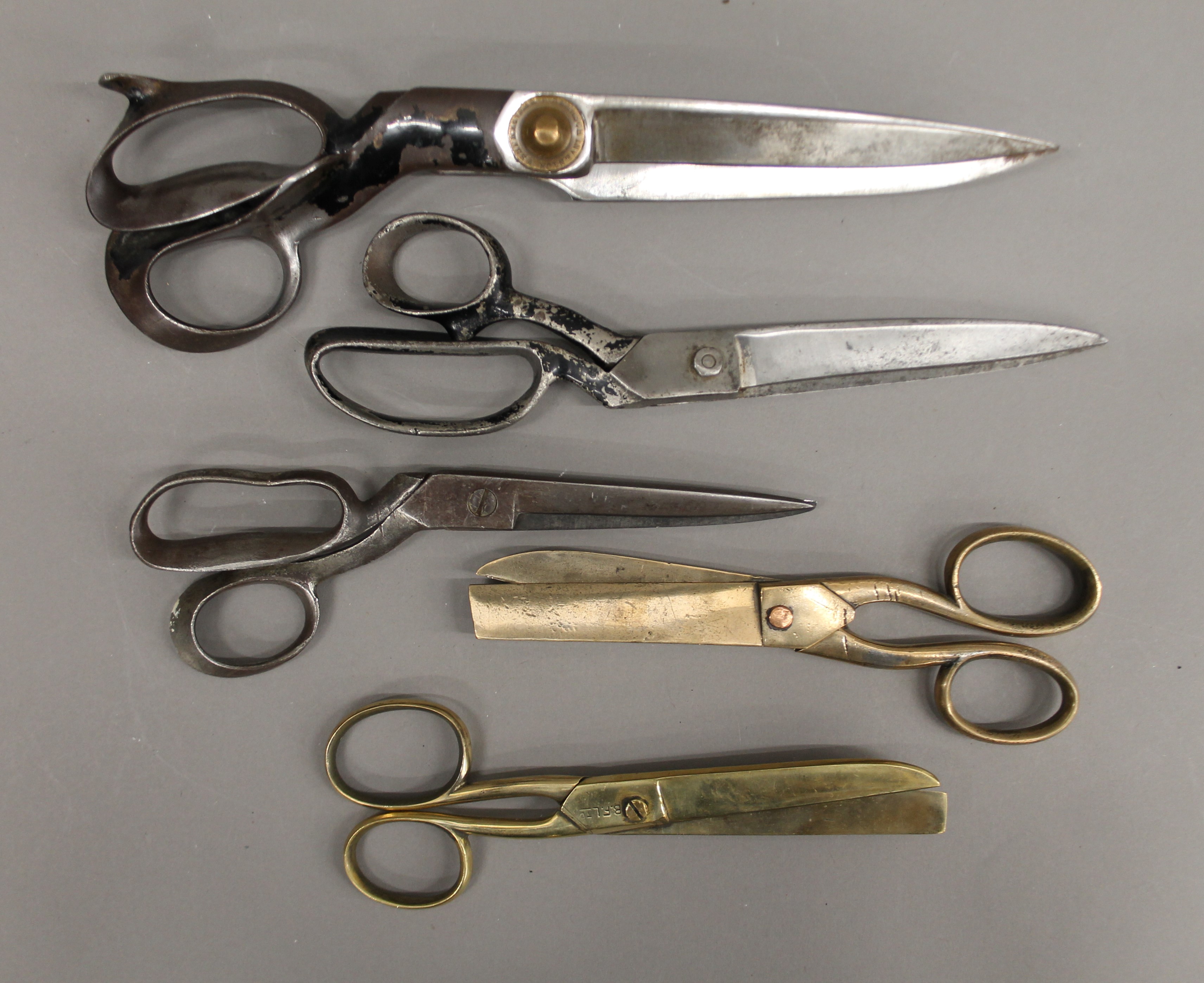 Three large tailors scissors and two pairs of bronze scissors.