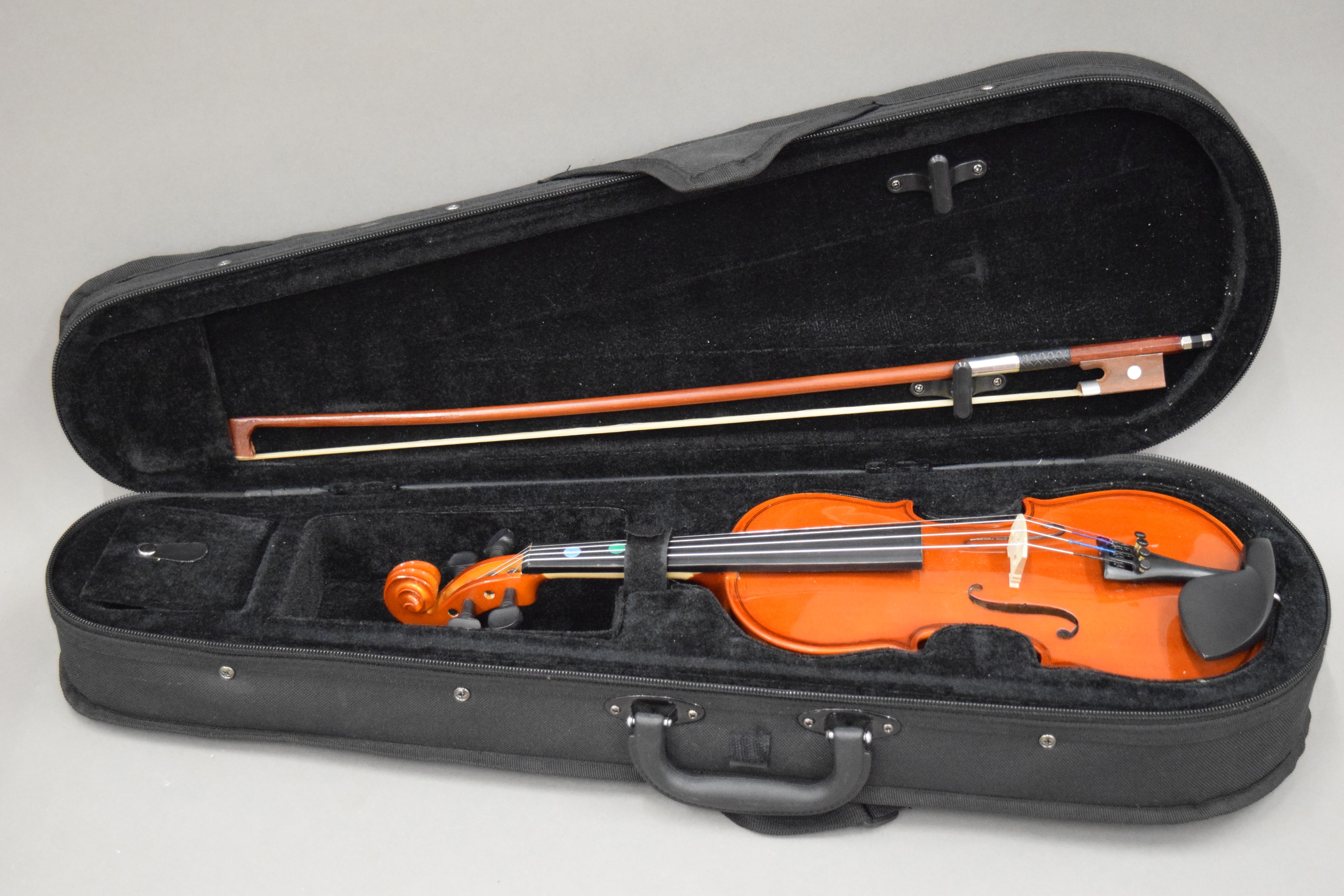 A modern child's violin and bow, cased.