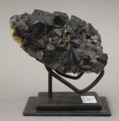 A black crystal specimen on stand.