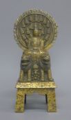 A gilt bronze figure of buddha seated above two temple lions. 27 cm high.